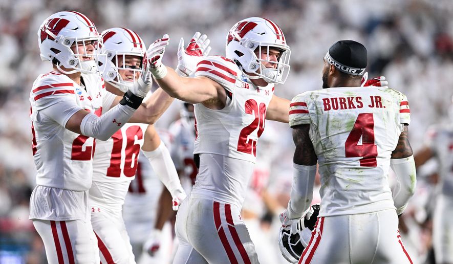Wisconsin players Matt Jung (29) and Marvin Burks Jr. (4) celebrate after their team's win over Penn State in an NCAA college football game, Saturday, Sept. 26, 2026, in State College, Pa. (AP Photo/Barry Reeger)