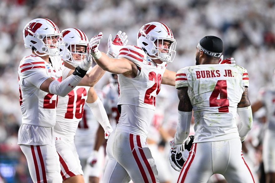 Wisconsin players Matt Jung (29) and Marvin Burks Jr. (4) celebrate after their team's win over Penn State in an NCAA college football game, Saturday, Sept. 26, 2026, in State College, Pa. (AP Photo/Barry Reeger)
