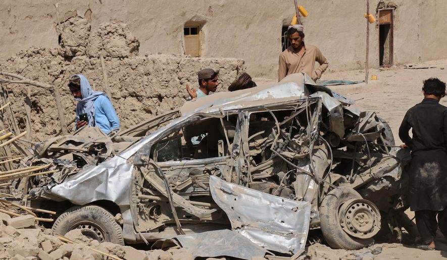 Afghan men inspect the wreckage of a vehicle at the site of what Afghanistan's Taliban government said was an overnight Pakistani airstrike in Helmand province, southwestern Afghanistan, Thursday, Oct. 1, 2026. (AP Photo/Abdul Khaliq)
