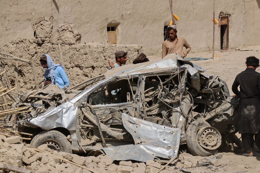 Afghan men inspect the wreckage of a vehicle at the site of what Afghanistan's Taliban government said was an overnight Pakistani airstrike in Helmand province, southwestern Afghanistan, Thursday, Oct. 1, 2026. (AP Photo/Abdul Khaliq)
