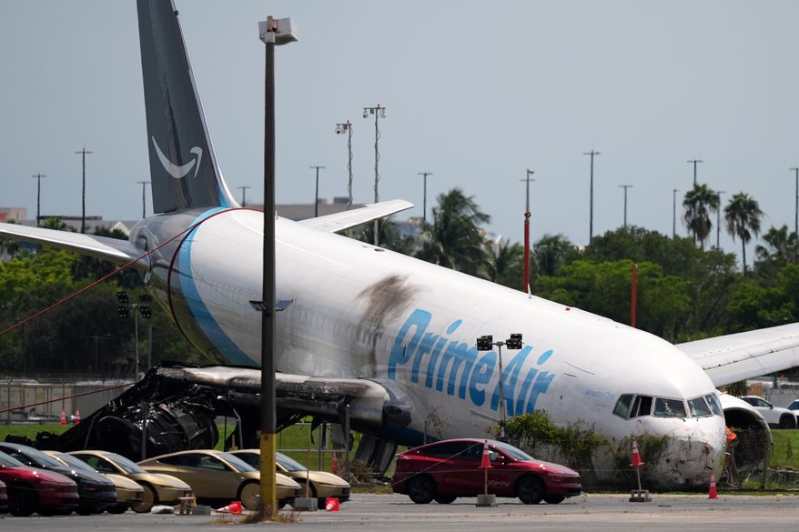 An Amazon cargo plane lies damaged near a parking lot two days after overshooting a runway at Miami International Airport, Tuesday, Sept. 8, 2026, in Miami. (AP Photo/Rebecca Blackwell)