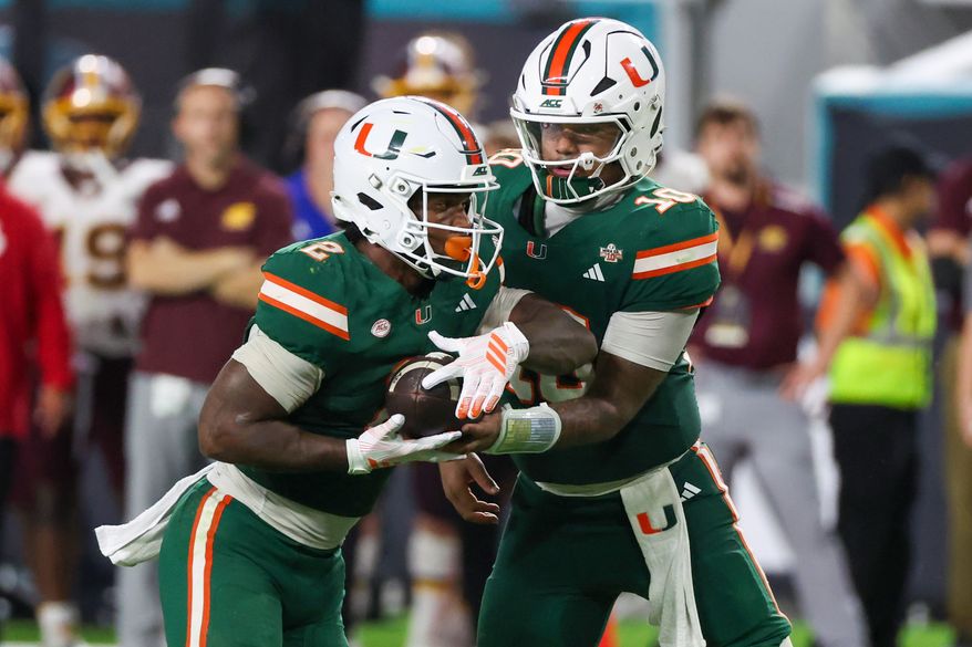 Miami quarterback Darian Mensah (10) hands off the ball to running back Jordan Lyle (2) against Central Michigan during the second half of an NCAA college football game, Saturday, Sept. 26, 2026, in Miami Gardens, Fla. (AP Photo/David Santiago)