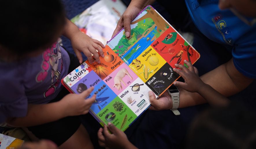 Children look through a book of first words at a Head Start preschool in Immokalee, Fla., Thursday, Sept. 10, 2026. (AP Photo/Rebecca Blackwell)