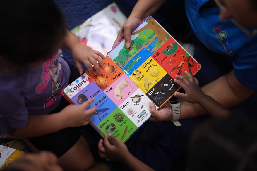 Children look through a book of first words at a Head Start preschool in Immokalee, Fla., Thursday, Sept. 10, 2026. (AP Photo/Rebecca Blackwell)
