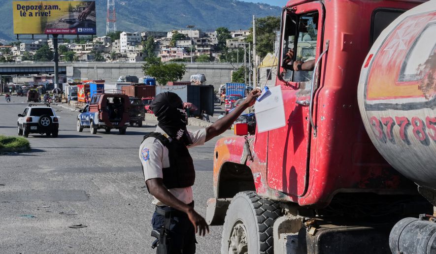A police officer interacts with a truck driver as he patrols at an intersection in Port-au-Prince, Haiti, Tuesday, Sept. 29, 2026. (AP Photo/Odelyn Joseph)