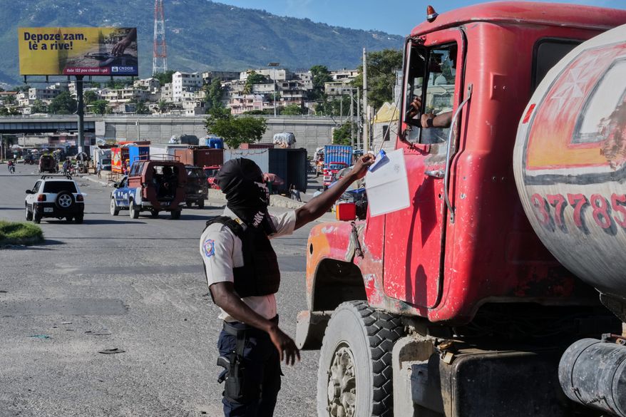 A police officer interacts with a truck driver as he patrols at an intersection in Port-au-Prince, Haiti, Tuesday, Sept. 29, 2026. (AP Photo/Odelyn Joseph)