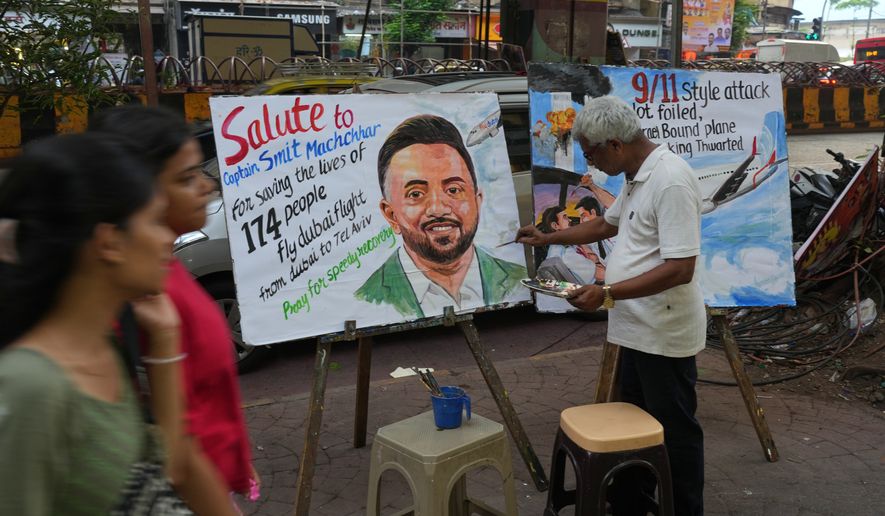 A teacher from Gurukul School of Art paints a portrait honoring Smit Machchhar,, an Indian pilot with FlyDubai, in Mumbai, India, Thursday, Oct. 1, 2026.(AP Photo/Rafiq Maqbool)