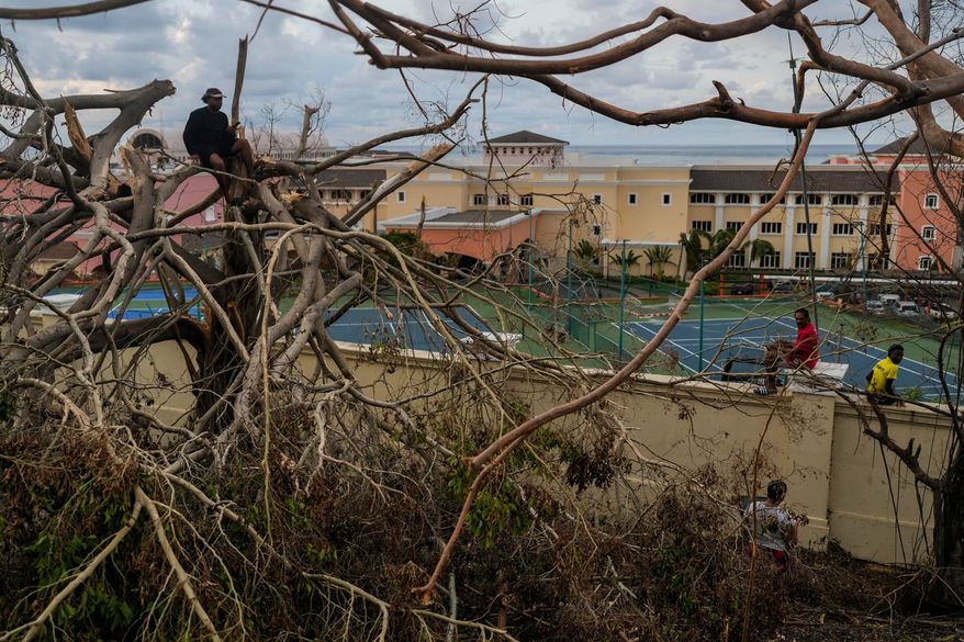 FILE - Locals gather next to a resort in Montego Bay, Jamaica, Oct. 31, 2025, in the aftermath of Hurricane Melissa. (AP Photo/Matias Delacroix, File)