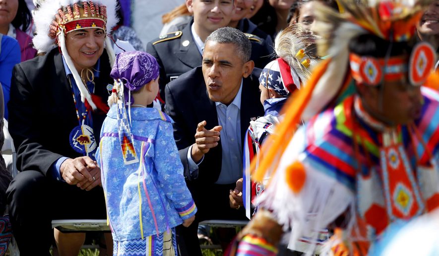 President Barack Obama talks to two young boys during a Native American dance on the Standing Rock Indian Reservation Friday, June 13, 2014, photo in Cannon Ball, N.D. (AP Photo/Charles Rex Arbogast,File)