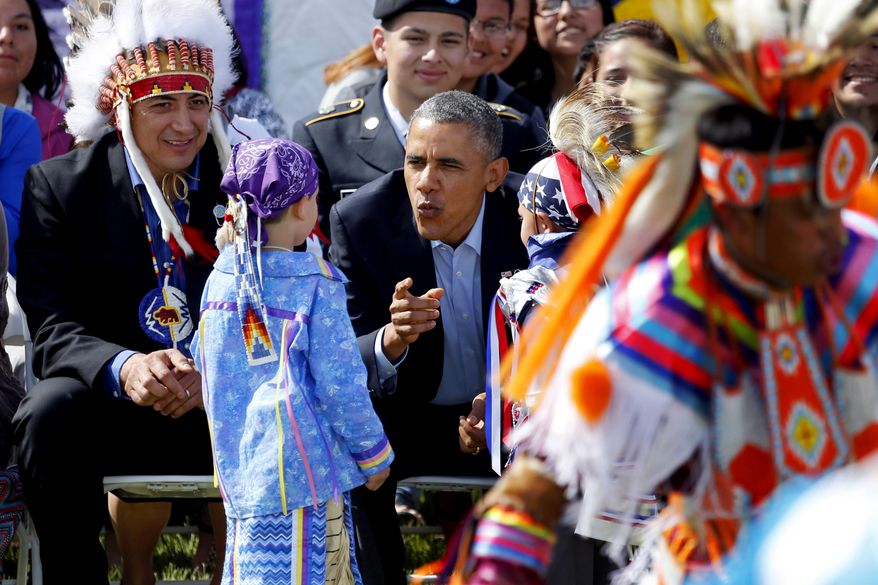 President Barack Obama talks to two young boys during a Native American dance on the Standing Rock Indian Reservation Friday, June 13, 2014, photo in Cannon Ball, N.D. (AP Photo/Charles Rex Arbogast,File)