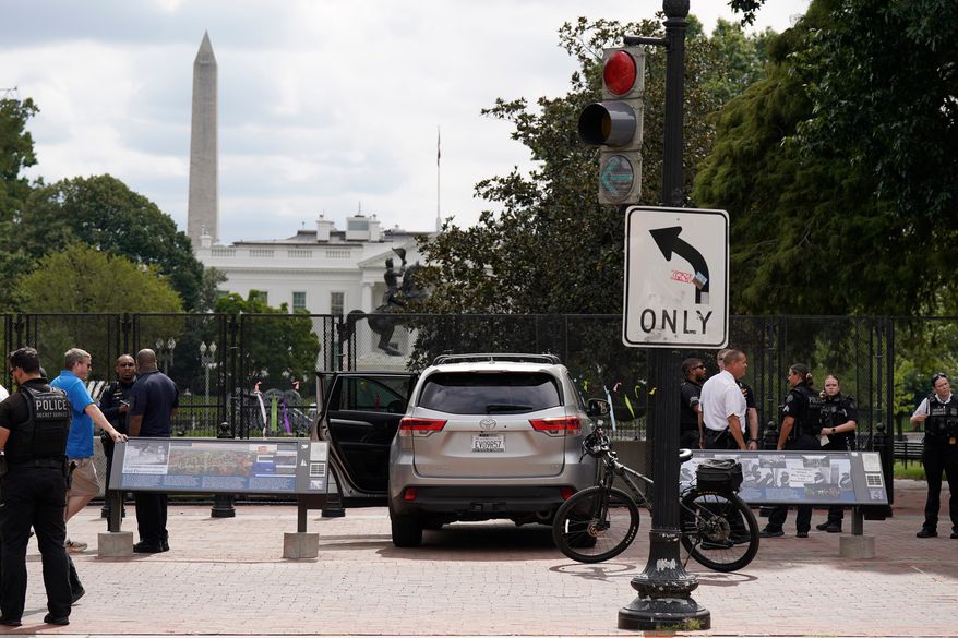 U.S. Secret Service Police stand near a car that sits parked on a sidewalk near the White House after the driver was arrested, Saturday, Sept. 19, 2026, in Washington. (AP Photo/Jose Luis Magana)