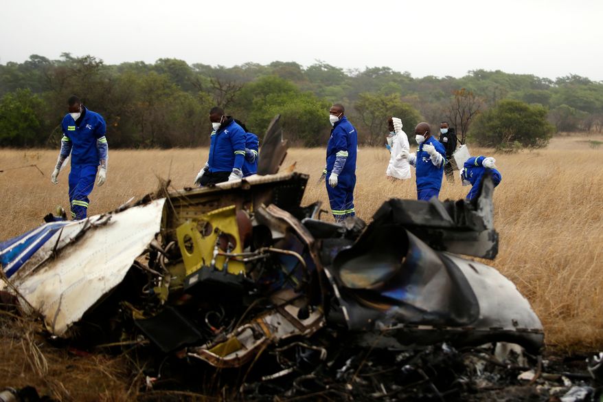Mortuary personnel work at the scene of a helicopter crash that killed Zimbabwean businessman Wicknell Chivayo, his wife and others at Kudenga Farm near Marondera, Zimbabwe, Thursday, Oct. 1, 2026. (AP Photo)