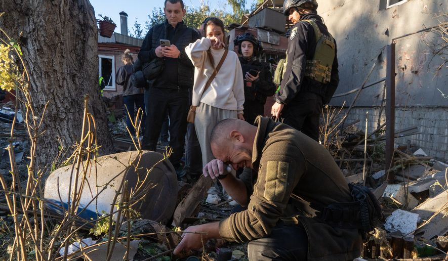 A man cries next to the body of his grandmother killed in a Russian airstrike on a residential neighborhood in Kharkiv, Ukraine, Friday, Oct. 2, 2026. (AP Photo/Andrii Marienko)