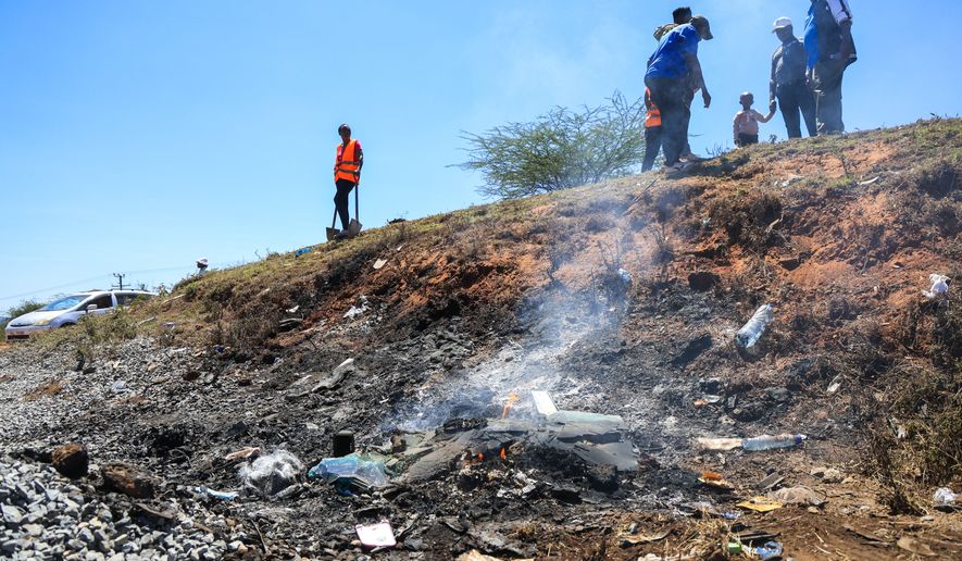 People gather at the scene where a 14-seater mini bus was involved in an accident killing all the passengers, in the Salama area, Makueni County, Eastern Kenya, Saturday, Oct. 3, 2026. (AP Photo/Andrew Kasuku)