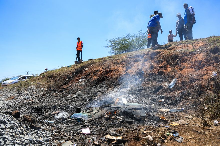 People gather at the scene where a 14-seater mini bus was involved in an accident killing all the passengers, in the Salama area, Makueni County, Eastern Kenya, Saturday, Oct. 3, 2026. (AP Photo/Andrew Kasuku)