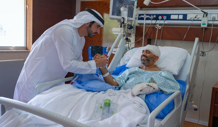 In this photo provided by the Government of Dubai Media Office, Dubai Crown Prince Sheikh Hamdan bin Mohammed bin Rashid Al Maktoum, left, visits injured Indian Flydubai Capt. Smit Machchhar at a hospital in Abu Dhabi, United Arab Emirates, Friday, Oct. 2, 2026. (Government of Dubai Media Office via AP)