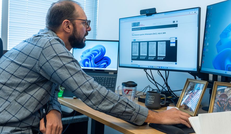 Smithsonian's Data Scientist Mike Trizna, looks on a computer monitor at a July 8, 1809 ,edition of the The Delaware Gazette from Wilmington, Del., as he works Sept. 29, 2026, in Washington. (AP Photo/Manuel Balce Ceneta)
