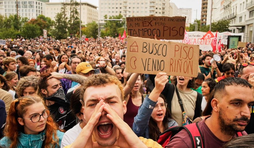 People demonstrate to demand stronger laws to protect renters in Madrid, Spain Saturday, Oct. 3, 2026. The banner reads in Spanish: "Looking for an apartment, selling a kidney". (AP Photo/Andrea Comas)