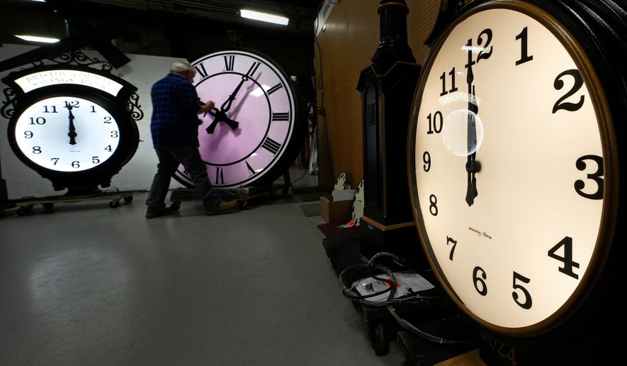 Clockmaker Scott Gow adjusts the hands of a clock at the Electric Time Company, Oct. 30, 2024, in Medfield, Mass. (AP Photo/Charles Krupa, File)