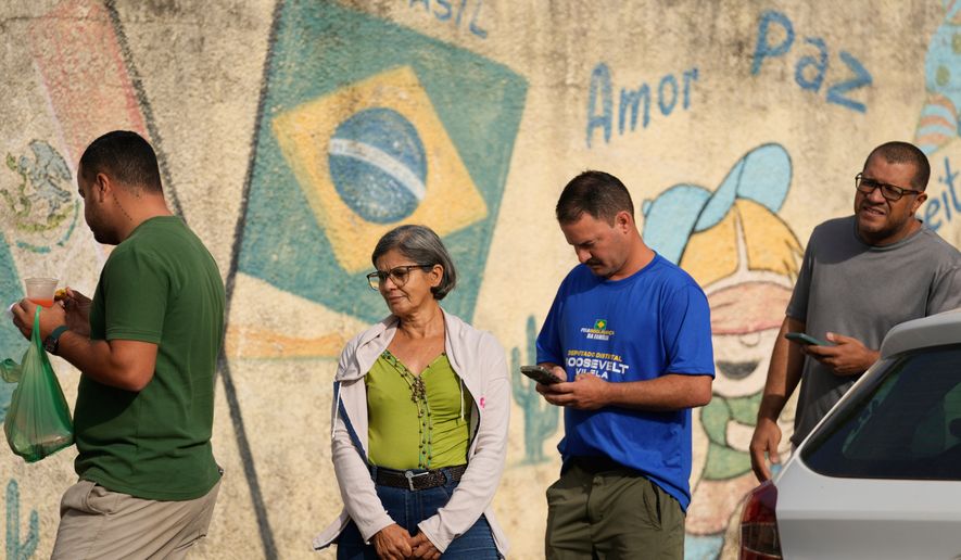 Voters line up at a polling station during general elections in Brasilia, Brasilia, Sunday, Oct. 4, 2026. (AP Photo/Eraldo Peres)