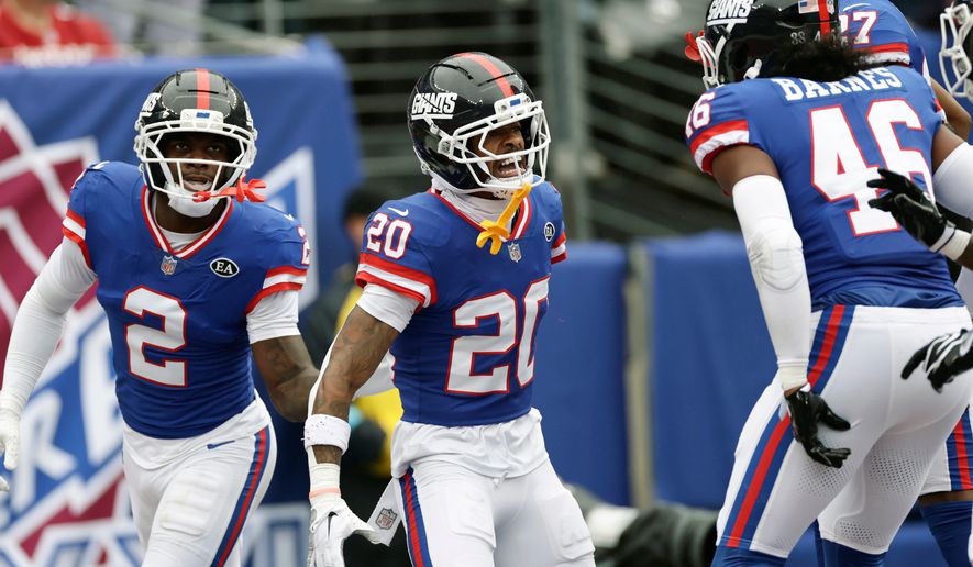 New York Giants cornerback Greg Newsome II (20) celebrates his interception against the Arizona Cardinals with Giants cornerback Deonte Banks (2) and Giants linebacker Zaire Barnes (46) during an NFL football game, in East Rutherford, N.J., Sunday, Oct. 4, 2026. (AP Photo/Adam Hunger)
