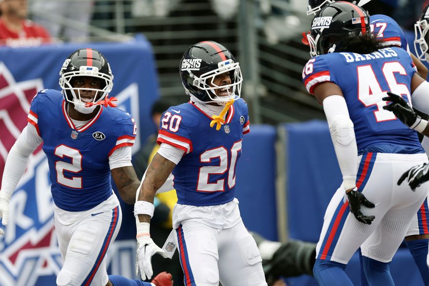 New York Giants cornerback Greg Newsome II (20) celebrates his interception against the Arizona Cardinals with Giants cornerback Deonte Banks (2) and Giants linebacker Zaire Barnes (46) during an NFL football game, in East Rutherford, N.J., Sunday, Oct. 4, 2026. (AP Photo/Adam Hunger)