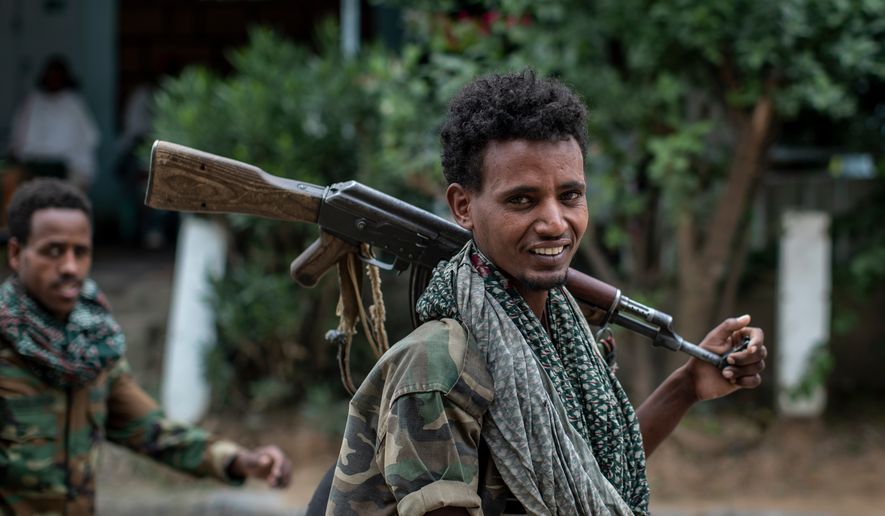 Fighters loyal to the Tigray People's Liberation Front (TPLF) walk along a street in the town of Hawzen, then controlled by the group, in the Tigray region of northern Ethiopia, May 7, 2021. (AP Photo/Ben Curtis, File)