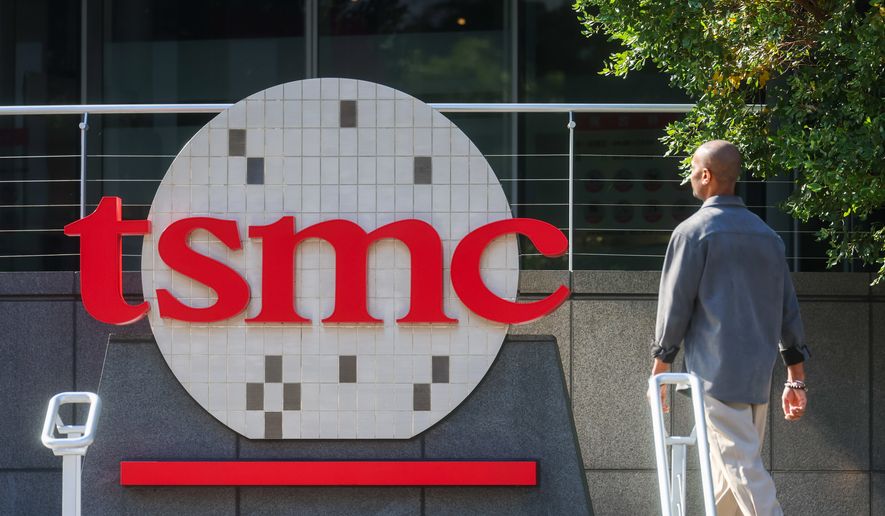 A worker walks past the logo of TSMC or Taiwan Semiconductor Manufacturing Corp., a Taiwanese multinational semiconductor contract manufacturing and design company, in Hsinchu, Taiwan, on Jan. 29, 2026. (AP Photo/Daniel Ceng, File)