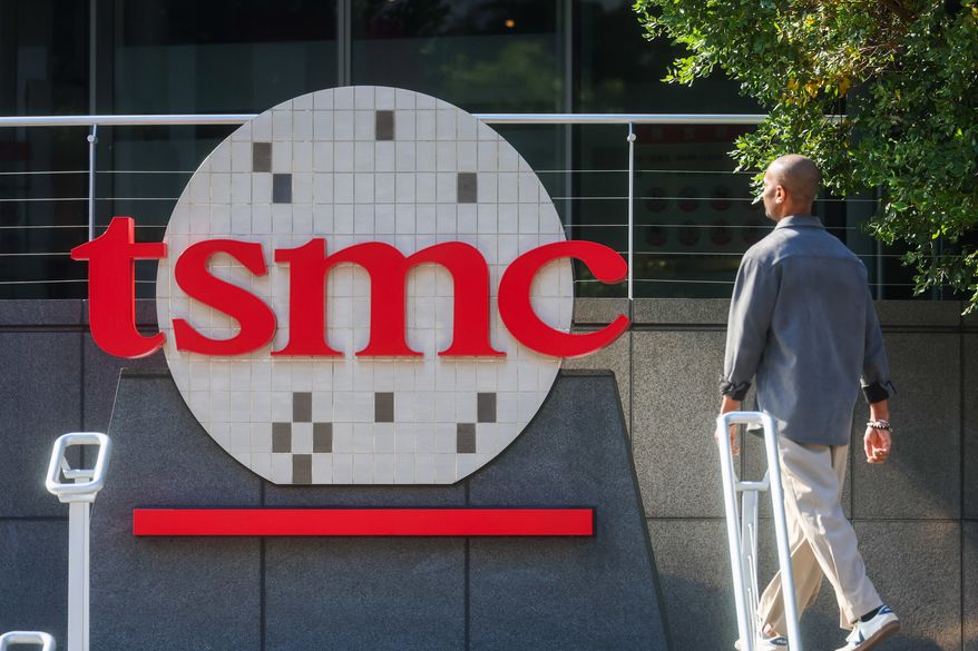 A worker walks past the logo of TSMC or Taiwan Semiconductor Manufacturing Corp., a Taiwanese multinational semiconductor contract manufacturing and design company, in Hsinchu, Taiwan, on Jan. 29, 2026. (AP Photo/Daniel Ceng, File)