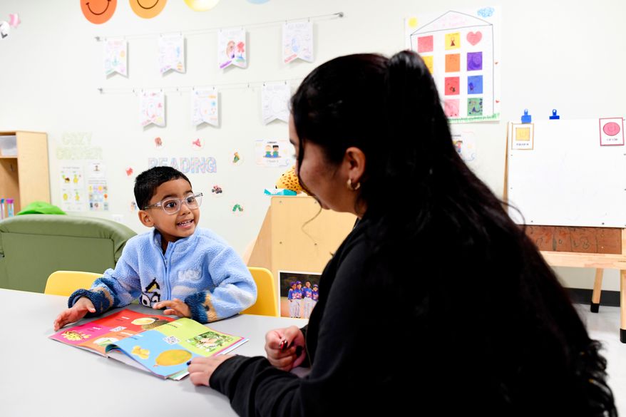Joanna Isitt, 28, reads with her son, Xavier Rogers, 4, before teaching her Head Start class at Hometown Child Care on Wednesday, Sept. 23, 2026, in Aurora, Ill. (AP Photo/Octavio Jones)