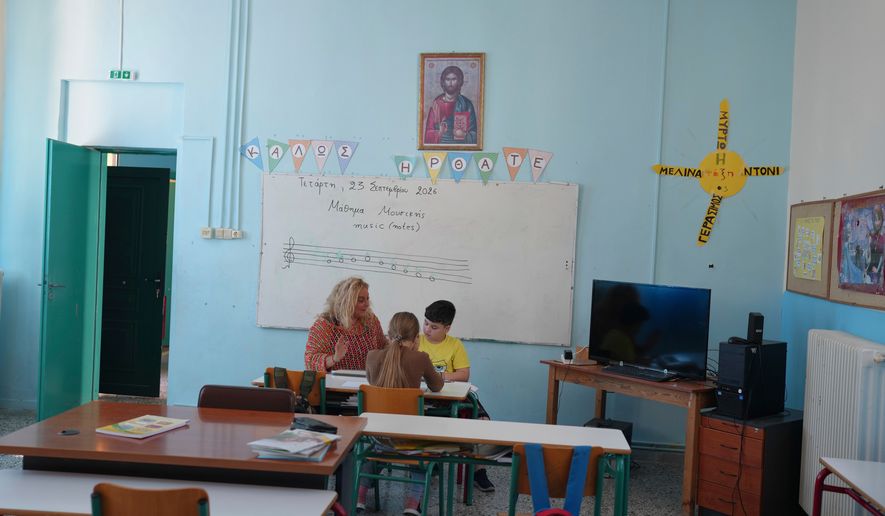 Teacher Chryssa Ntalaka teaches music to the two students of Kalamos Primary School, including Gerasimos Mitsopoulos, 11, right, on the island of Kalamos in the Ionian Sea, western Greece, Wednesday, Sept. 23, 2026. (AP Photo/Petros Giannakouris)
