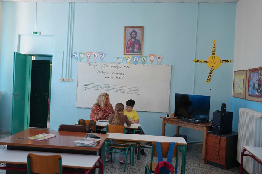 Teacher Chryssa Ntalaka teaches music to the two students of Kalamos Primary School, including Gerasimos Mitsopoulos, 11, right, on the island of Kalamos in the Ionian Sea, western Greece, Wednesday, Sept. 23, 2026. (AP Photo/Petros Giannakouris)