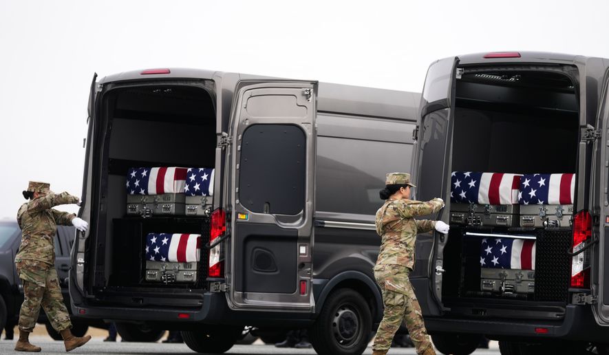 FILE - Door attendants secure the doors of the transfer vans containing the remains of U.S. Army Reserve soldiers Maj. Jeffrey O'Brien, Maj. Cody Khork, Chief Warrant Officer 3 Robert Marzan, Master Sgt. Class Nicole Amor, Master Sgt. Class Noah Tietjens, Sgt. Declan Coady, during a casualty return, March 7, 2026, at Dover Air Force Base, Del., who were killed in a drone strike at a command center in Kuwait after the U.S. and Israel launched its military campaign against Iran. (AP Photo/Mark Schiefelbein, File)