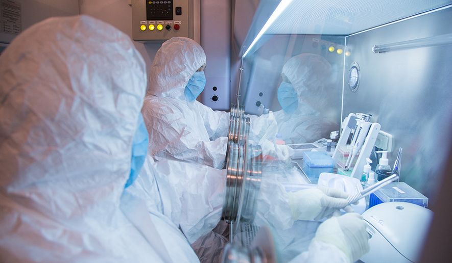 This undated photo released by the Irkutsk Anti-Plague Research Institute of Siberia and Far East, shows the institute workers in a lab. (The Irkutsk Anti-Plague Research Institute of Siberia and Far East via AP)