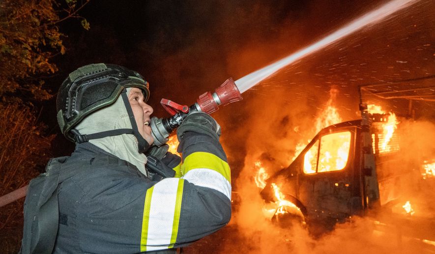 A rescue worker tries to put out a fire of a residential house damaged in a Russian drone strike on Kharkiv, Ukraine, Sunday, Oct. 4, 2026. (AP Photo/Andrii Marienko)