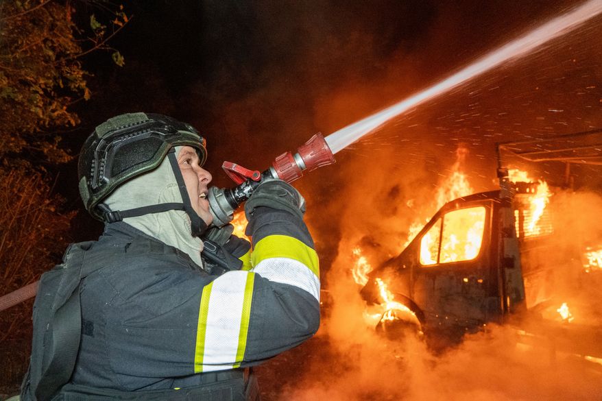 A rescue worker tries to put out a fire of a residential house damaged in a Russian drone strike on Kharkiv, Ukraine, Sunday, Oct. 4, 2026. (AP Photo/Andrii Marienko)