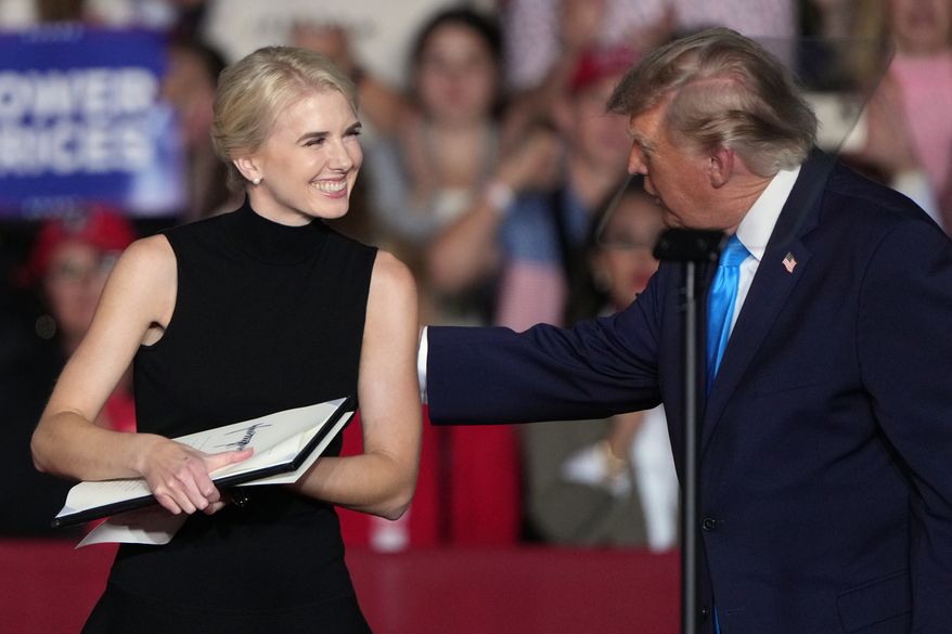 President Donald Trump talks with White House aide Natalie Harp at a campaign rally at the Pinnacle Bank Expo Center, Monday, Oct. 5, 2026, in Grand Island, Neb. (AP Photo/Charlie Riedel)