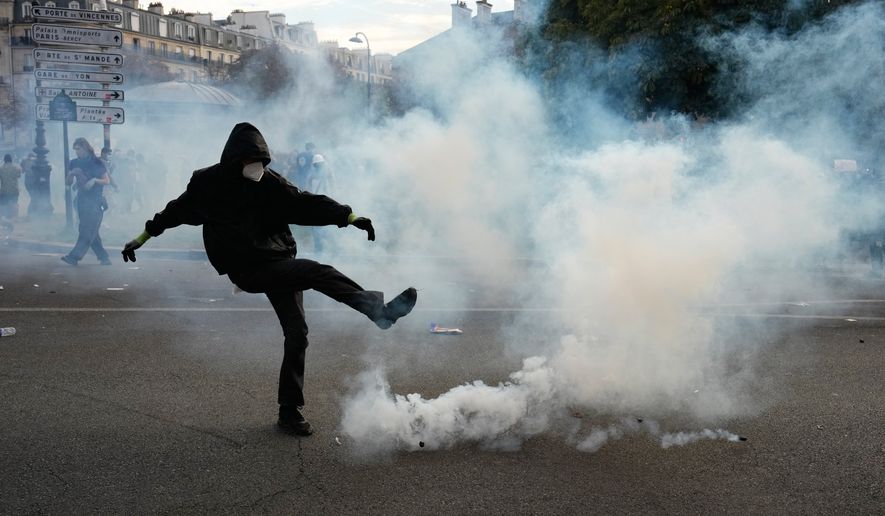 A protesters kicks a teargas canister during scuffles following a demonstration against under-resourced schools, in Paris, Tuesday, Oct. 6, 2026. (AP Photo/Teresa Suarez)