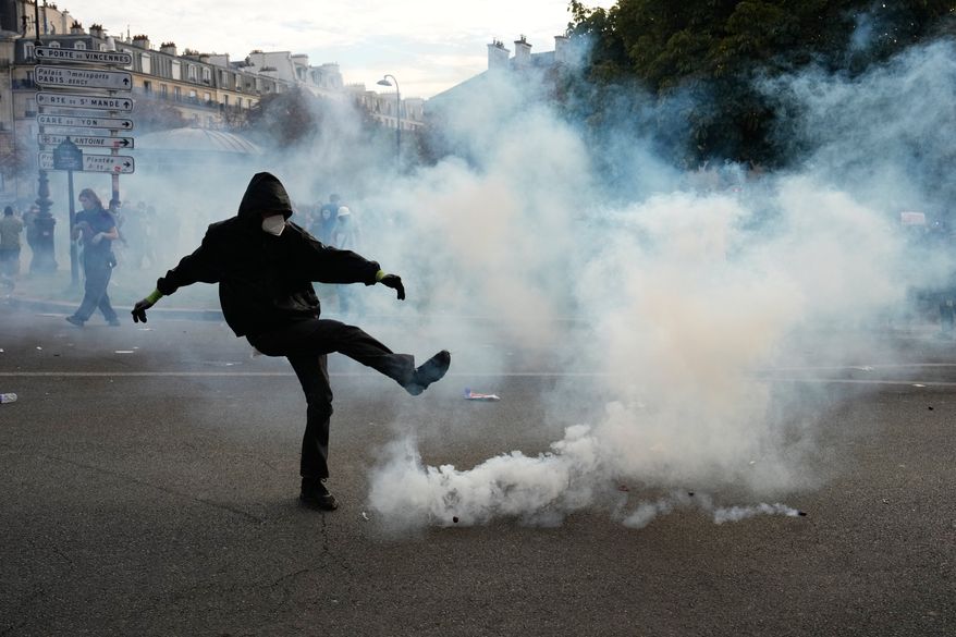 A protesters kicks a teargas canister during scuffles following a demonstration against under-resourced schools, in Paris, Tuesday, Oct. 6, 2026. (AP Photo/Teresa Suarez)