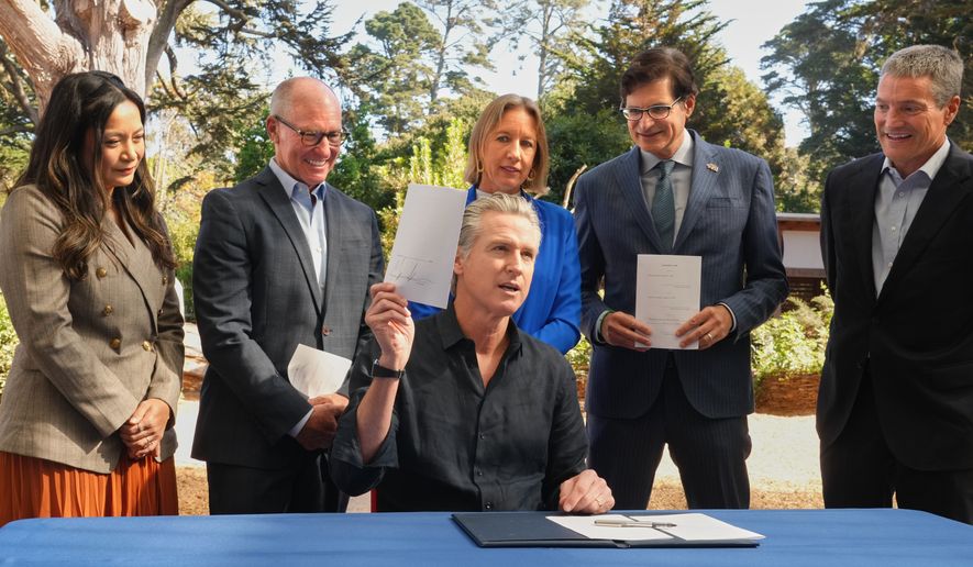 California Gov. Gavin Newsom displays one of the conservation bills he signed during a visit to the California Academy of Sciences in San Francisco, Tuesday, Sept. 29, 2026. (AP Photo/Rich Pedroncelli)