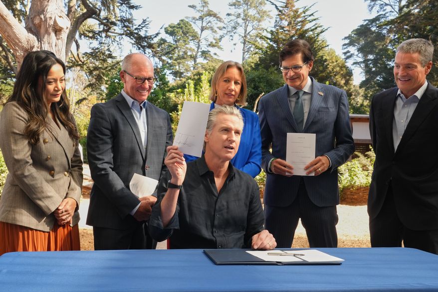 California Gov. Gavin Newsom displays one of the conservation bills he signed during a visit to the California Academy of Sciences in San Francisco, Tuesday, Sept. 29, 2026. (AP Photo/Rich Pedroncelli)