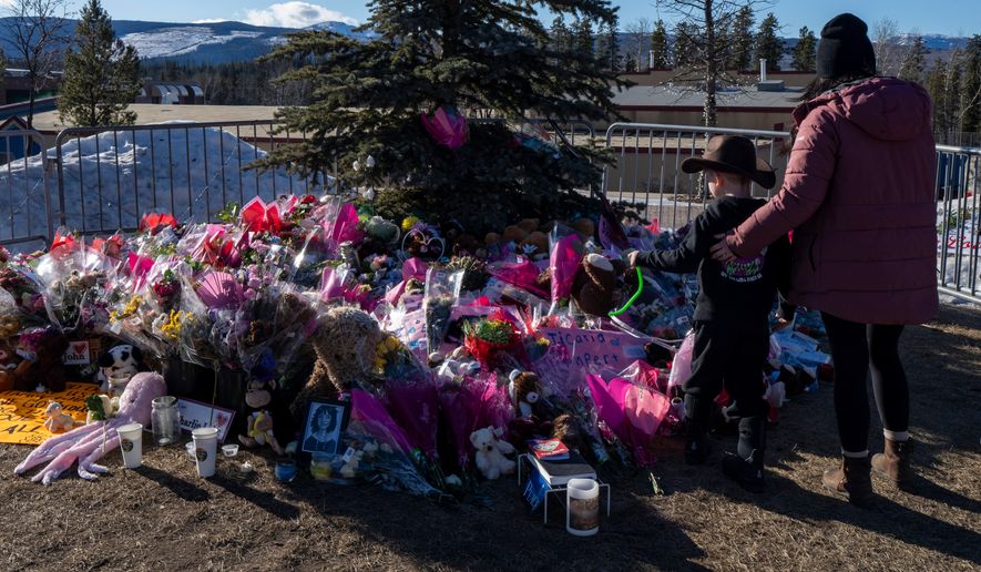 A mother and son pay their respects at a memorial for the victims of a mass shooting in Tumbler Ridge, British Columbia, Canada, Feb. 14, 2026. (Christinne Muschi/The Canadian Press via AP, File)