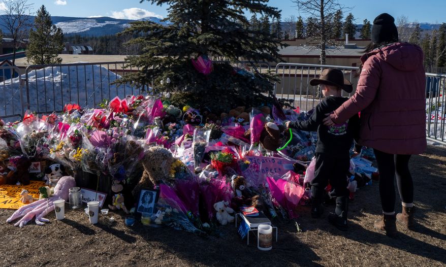 A mother and son pay their respects at a memorial for the victims of a mass shooting in Tumbler Ridge, British Columbia, Canada, Feb. 14, 2026. (Christinne Muschi/The Canadian Press via AP, File)