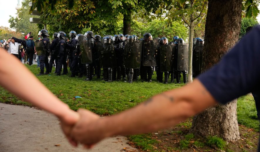 Protesters face police during a demonstration against under-resourced schools, in Paris, Tuesday, Oct. 6, 2026. (AP Photo/Teresa Suarez)