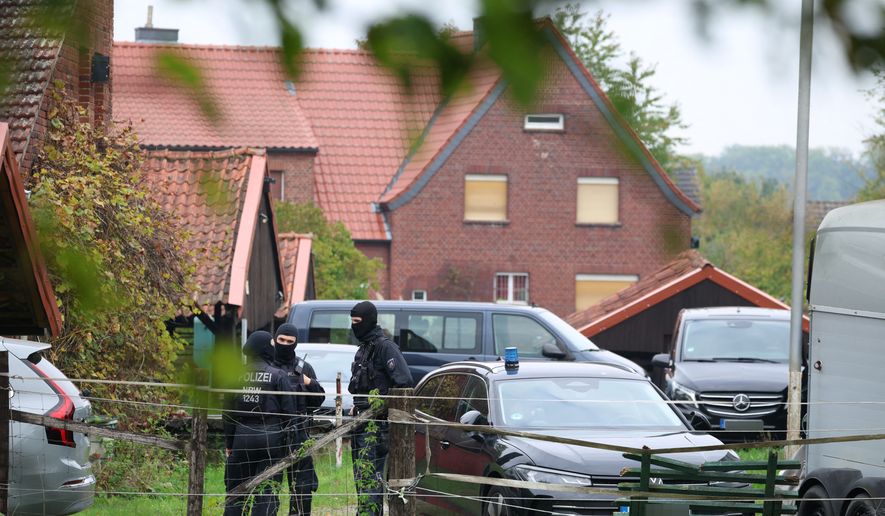 Police officers are standing in front of the home of former president of the Federal Intelligence Service, or BND, August Hanning, 80, who was arrested on suspicion of espionage, in Nordwalde, Germany, Tuesday, Oct. 6, 2026. (Christoph Reichwein/dpa via AP)