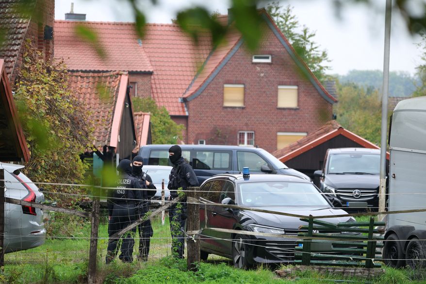 Police officers are standing in front of the home of former president of the Federal Intelligence Service, or BND, August Hanning, 80, who was arrested on suspicion of espionage, in Nordwalde, Germany, Tuesday, Oct. 6, 2026. (Christoph Reichwein/dpa via AP)