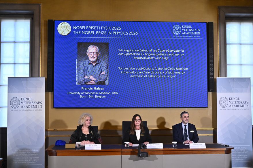 A portrait of Francis Halzen is shown on the screen as Eva Olsson, Ellen Moons, and Mark Pearce announce as the recipient of the 2026 Nobel Prize in Physics during a press conference at the Royal Swedish Academy of Sciences, Stockholm, Sweden, Oct. 6, 2026. (Christine Olsson/TT News Agency via AP)