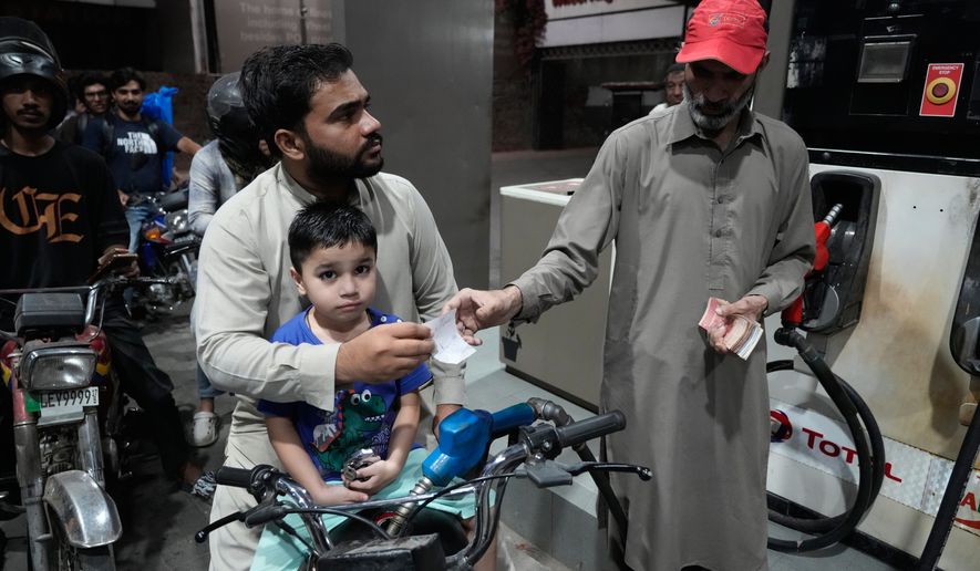 A motorcyclist gets fuel on subsidised rates in a recently government scheme for low income people, at a fuel station, in Lahore, Pakistan, Tuesday, Oct. 6, 2026. (AP Photo/K.M. Chaudary)