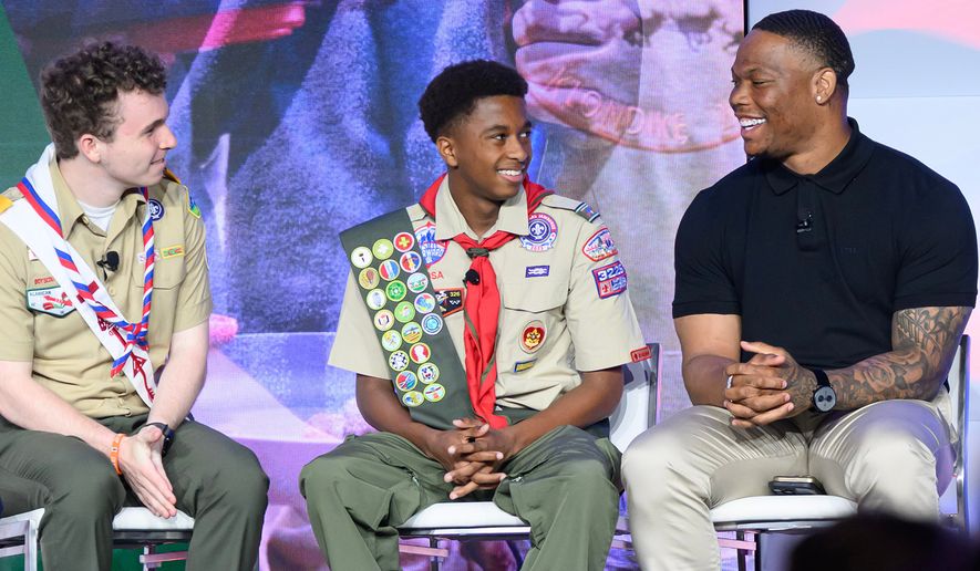 This photo provided by Omnicom shows Houston Texans running back David Montgomery, right, speaking with two scouts on stage at the Scouting American national meeting in May 2026, in Dallas. (Michael Roytek/Scouting America/Omnicom via AP)