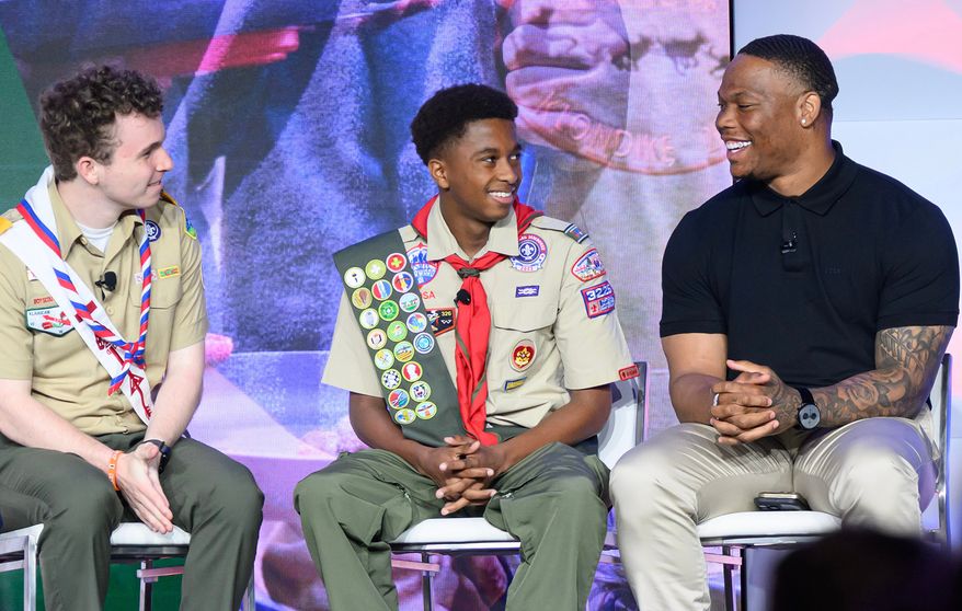 This photo provided by Omnicom shows Houston Texans running back David Montgomery, right, speaking with two scouts on stage at the Scouting American national meeting in May 2026, in Dallas. (Michael Roytek/Scouting America/Omnicom via AP)